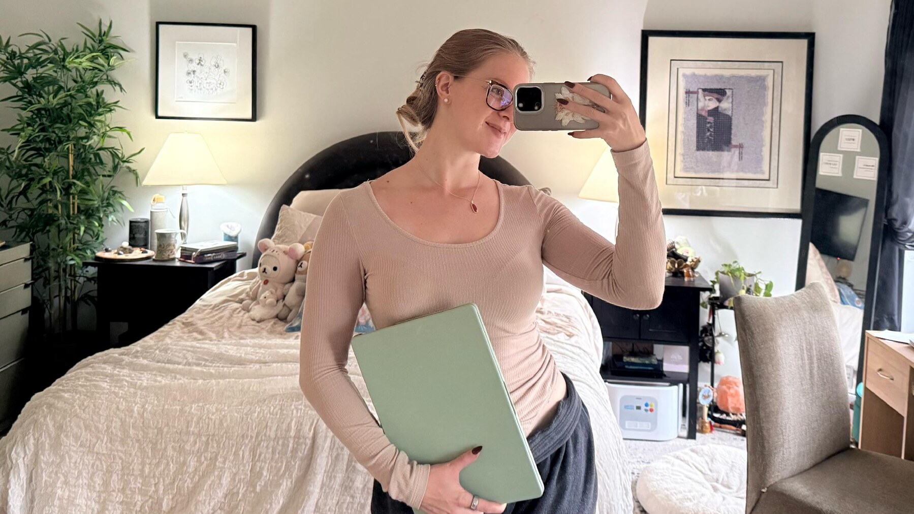 Shelby taking a mirror selfie with her laptop